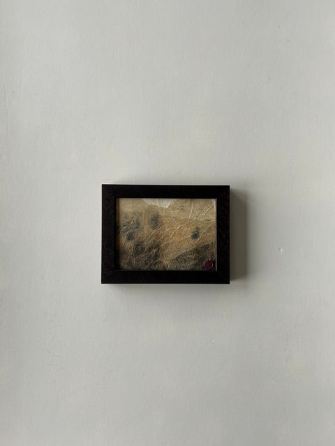 Framed abstract landscape artwork, inspired by japanese ink art, created with ink, charcoal and paper techniques. Encased in a walnut-style frame with a red wax stamp signature, blending traditional craftmanship with modern aesthetics